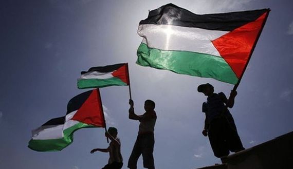 Boys wave Palestinian flags during a protest near the border between Israel and the northern Gaza Strip