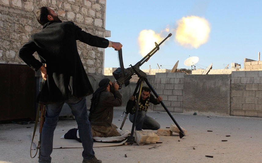 Free Syrian Army fighters fire at an Assad regime helicopter in Aleppo. (Reuters/Molhem Barakat)