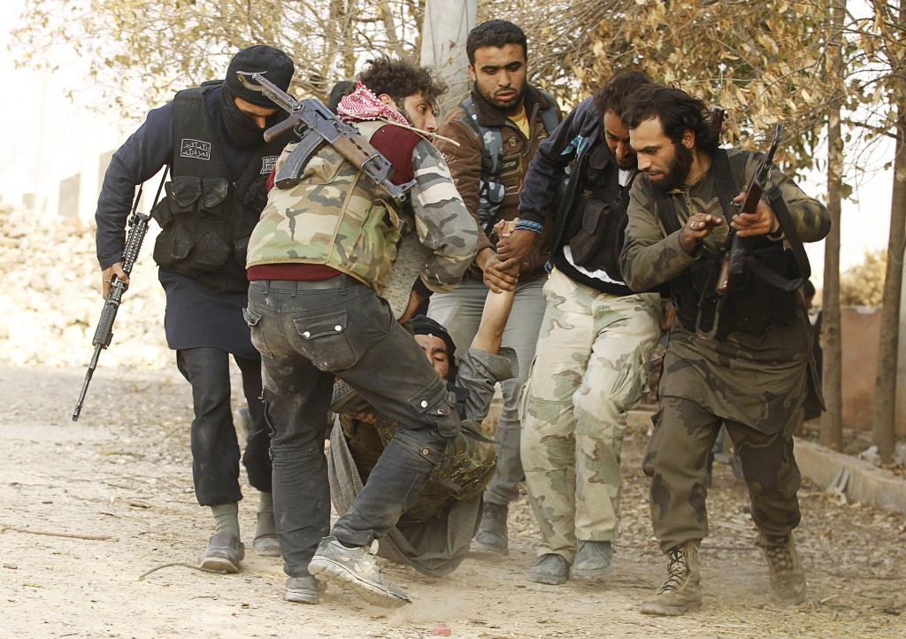 Free Syrian Army fighters carry a man wounded in clashes with Assad's fighters in Aleppo. (Reuters/Molhem Barakat)