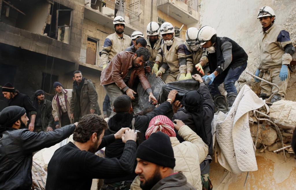 Free Syrian Army fighters pull a body from the rubble of an attack by Assad forces. (Reuters/Molhem Barakat)