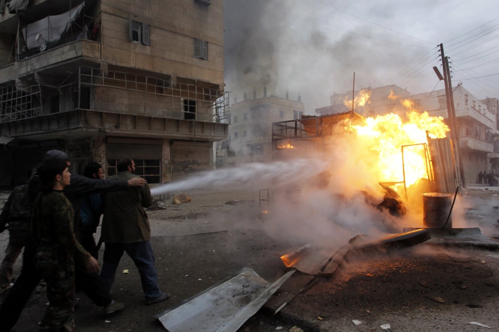 Aleppo residents attempt to put out a fire caused by shelling from Assad's forces. (Reuters/Molhem Barakat)