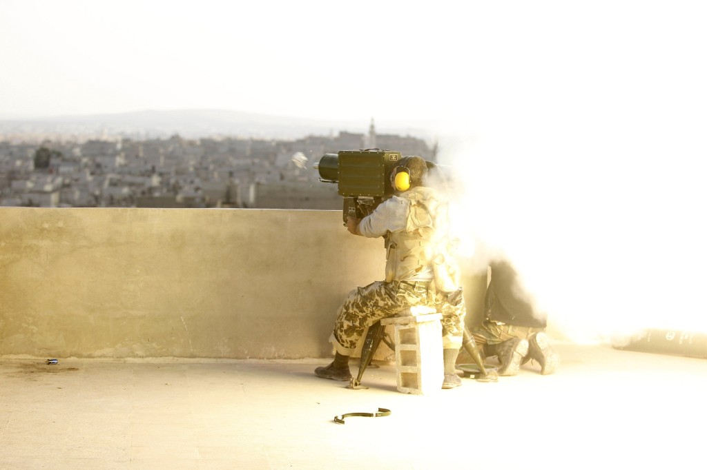 A rebel fighter launches an attack against the Syrian army's 80th Brigade Base. (Reuters/Molhem Barakat)
