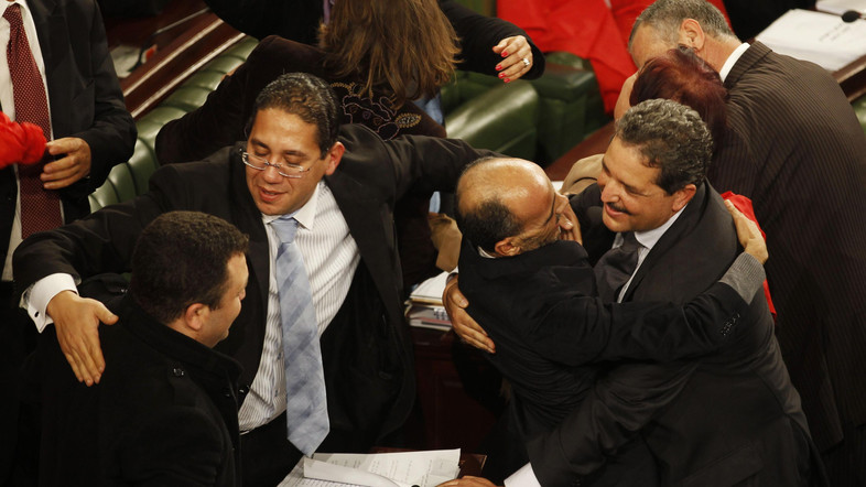 Members of the Tunisian parliament celebrate after approving the country's new constitution in the assembly building in Tunis