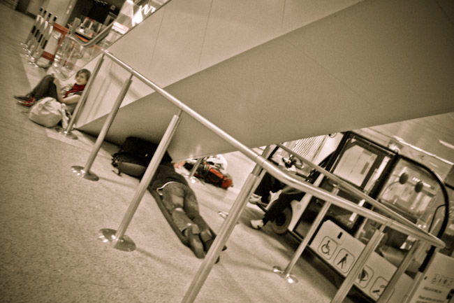 sleeping-in-airport-under-escalator