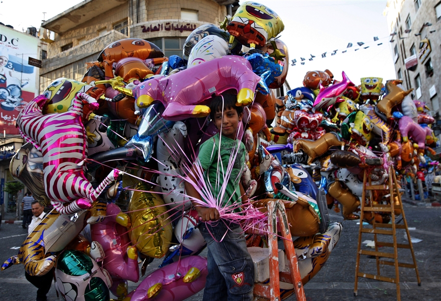 A Palestinian boy selling balloons for Eid festivals