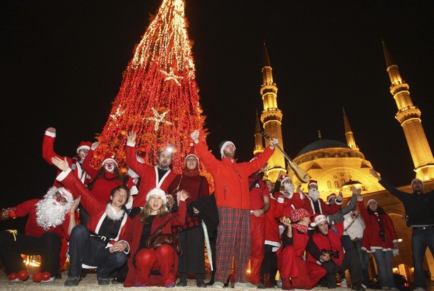 Lebanese students dressed up as Santa Claus and clowns celebrate in front of a giant Christmas tree in downtown Beirut