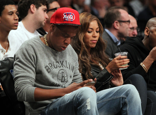 Jay-Z and Beyonce sitting in the front row at the Toronto Raptors vs. Brooklyn Nets at the Barclays Center