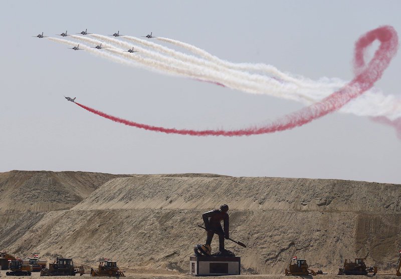 Egyptian Air Force planes performing stunts above a statue of a worker digging at the opening ceremony of the New Suez Canal in Ismailiya (Reuters/Amr Abdallah Dalsh)