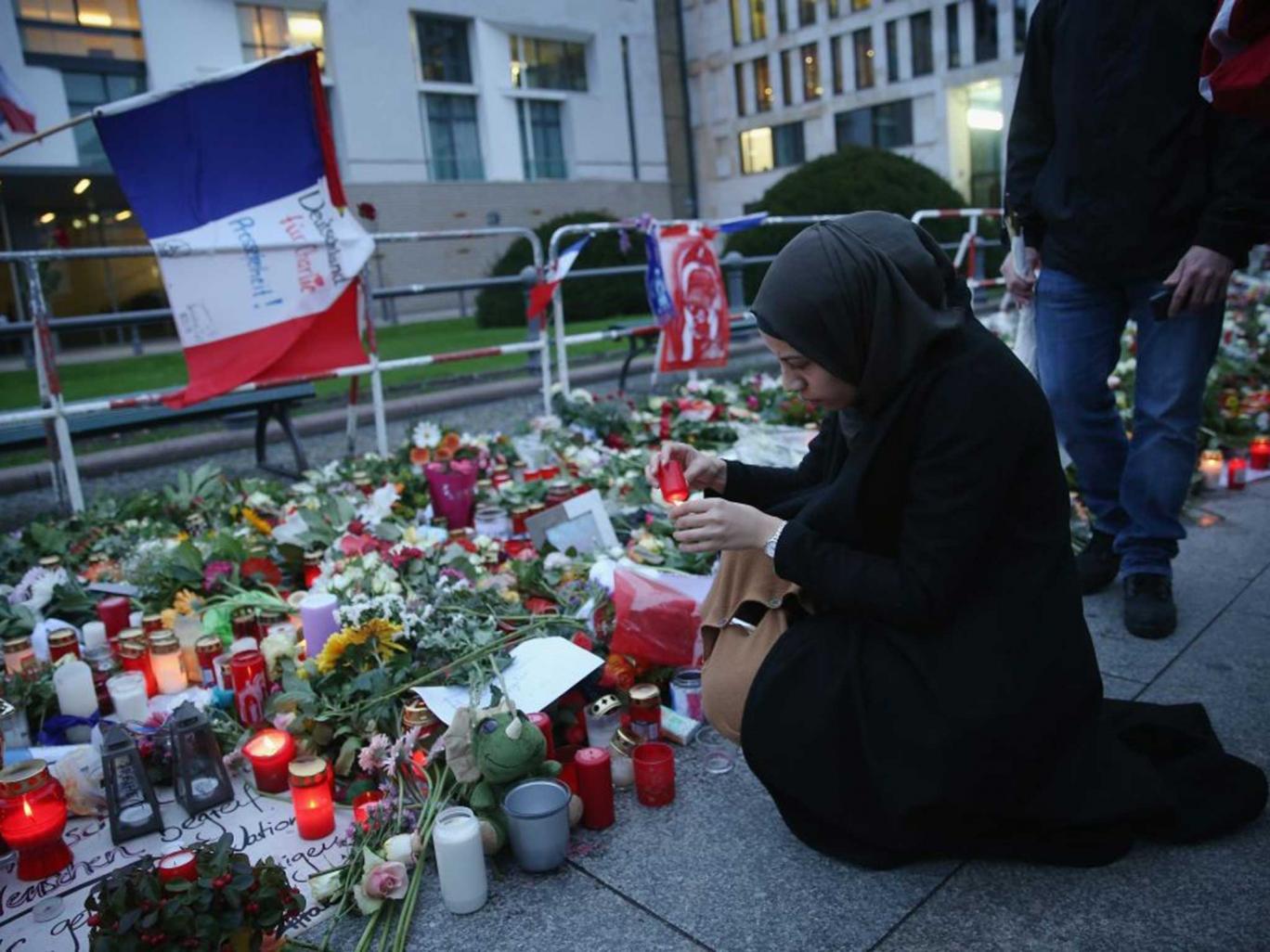 A Muslim woman lights a candle for the victims of the deadly Paris attacks that occurred Nov. 16, 2015.