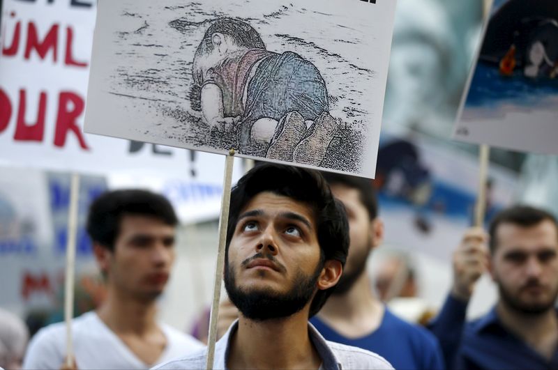 A man holds a drawing of drowned Syrian boy Alan Kurdi as a tribute during a protest for refugee rights. (Osman Orsal/Reuters)