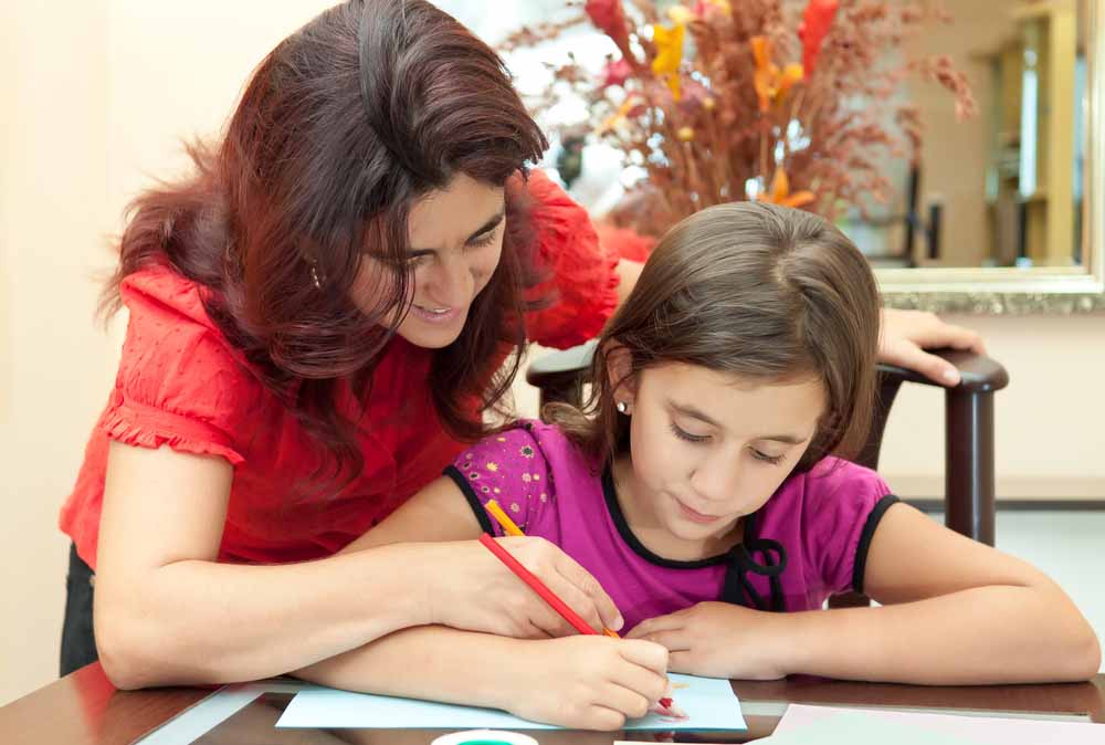 ethnic-mother-and-girl-doing-homework
