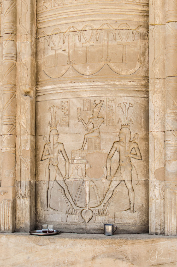 A cup of tea left beneath a wall carving in Luxor's Karnak Temple Complex