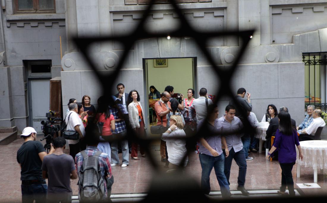 Egyptians gather inside Shaar Hashamayim synagogue as they wait to break their fast in Cairo, Egypt, Wednesday, July 9, 2014. The Jewish community in Egypt hosted for the first time an Iftar party, evening meal when Muslims break their fast during the Islamic month of Ramadan. (AP Photo/Amr Nabil)