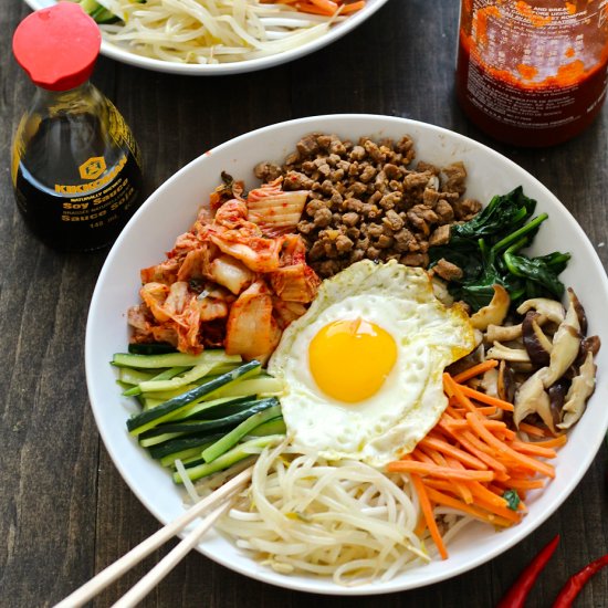 Bibimbap literally means "mixed rice." Bibimbap is served as a bowl of warm white rice topped with seasoned vegetables and chili pepper paste, soy sauce, or doenjang, a fermented soybean paste. A raw or fried egg and sliced meat (usually beef) are common additions. Via Food Gawker.