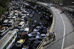 Egyptian men look down at a massive traffic jam in Attaba, a neighborhood of Cairo, Egypt, Friday, April 19, 2013. In Egypt, where rapid population growth has long strained the country’s decaying infrastructure and consumed vital resources like arable land, the birthrate has unexpectedly spiked for two years in a row, compounding the challenges facing a government that is already overwhelmed by emergencies. (Photo Credit/Tara Todras-Whitehill for the New York Times)